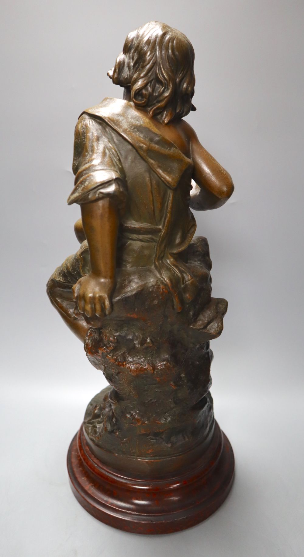 After August Moreau. A patinated spelter model of a seated youth, Enfant au Crabe, on marbled wood plinth, 49cm